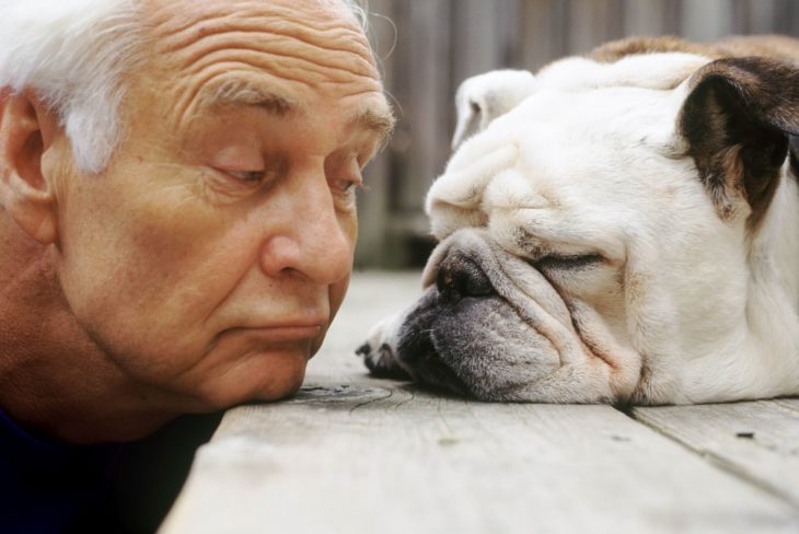 anciano levantando una ceja a un perro