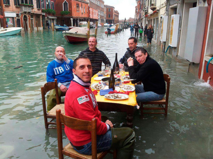 amigos comiendo en un lugar inundado 