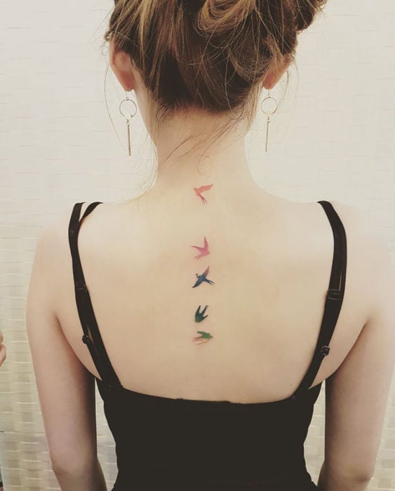 tatuajes minimalistas de aves en la espalda de una chica
