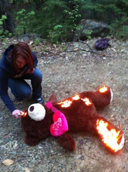 mujer quemando oso de peluche