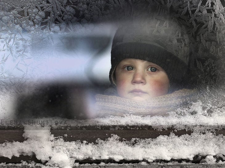 niño mirando por un vidrio