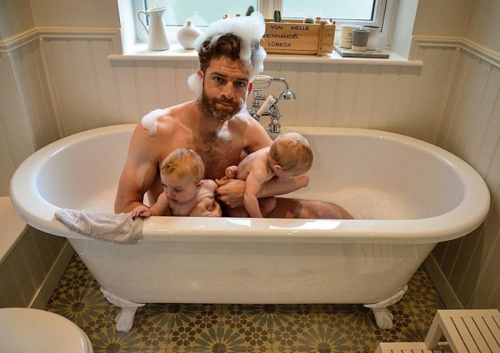hombre en la tina con sus bebés