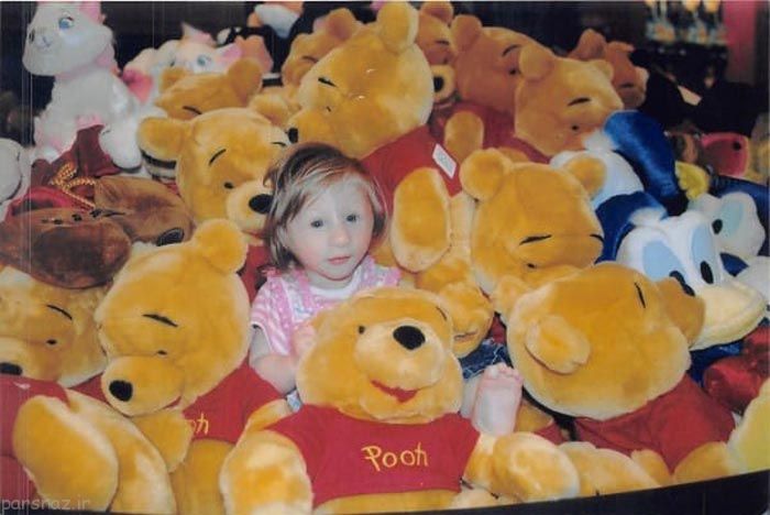 niña pequeñita en medio de peluches de winnie pooh