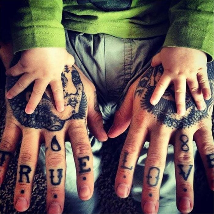 manos de bebé y su papá tatuado 