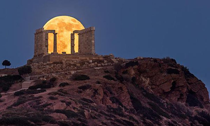 edificio griego en ruinas por el que se ve la luna