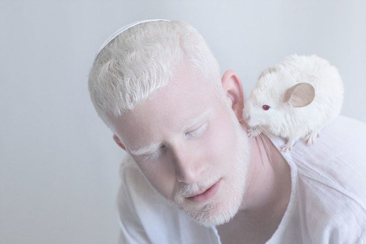 Hombre albino con un ratoncito en su hombro