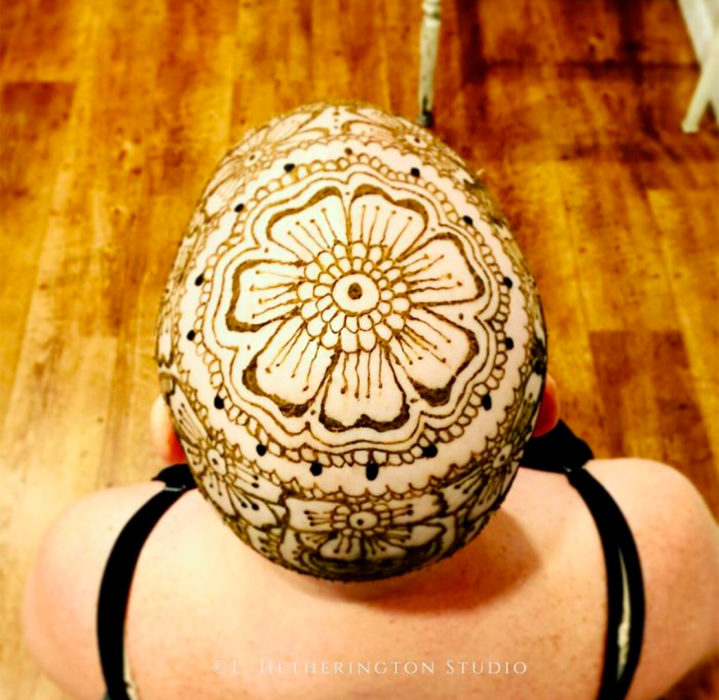 Mujer con un tatuaje en la cabeza hecho de henna