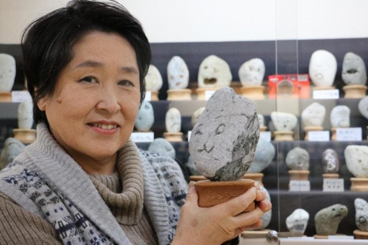 Una mujer con una piedra de su museo 