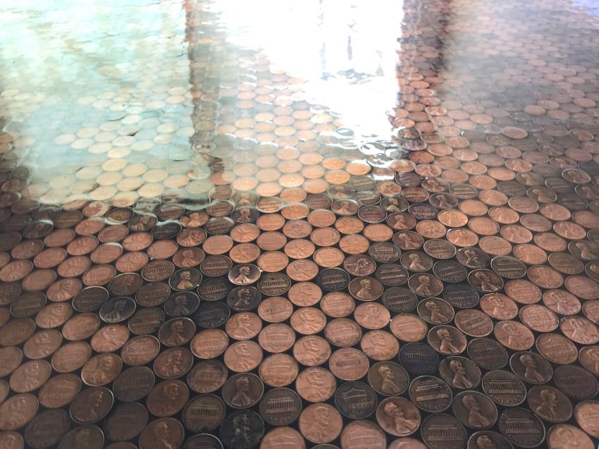 Utilizó monedas de centavo y pegamento para decorar el piso