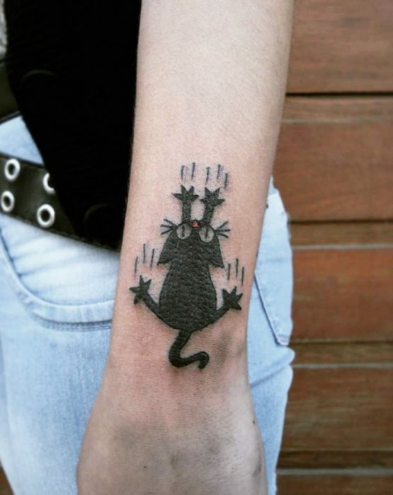 Tatuaje animado de gato resbalando por le brazo 