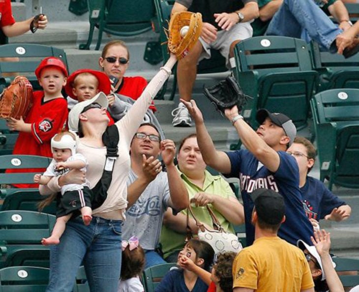 mujer con bebe atrapa una bola de béisbol 