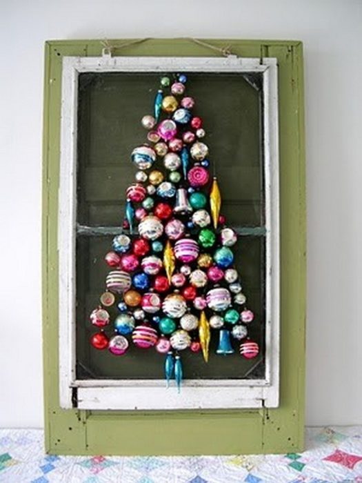 esferas forman árbol de navidad en una ventana