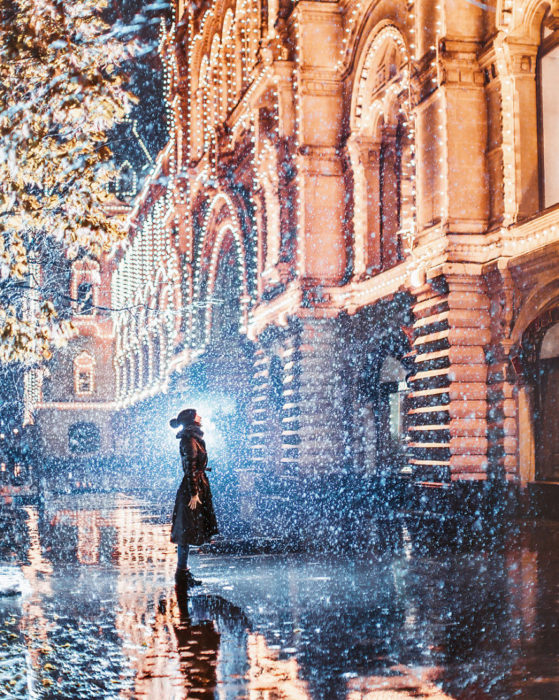 mujer mirando un edificio iluminado