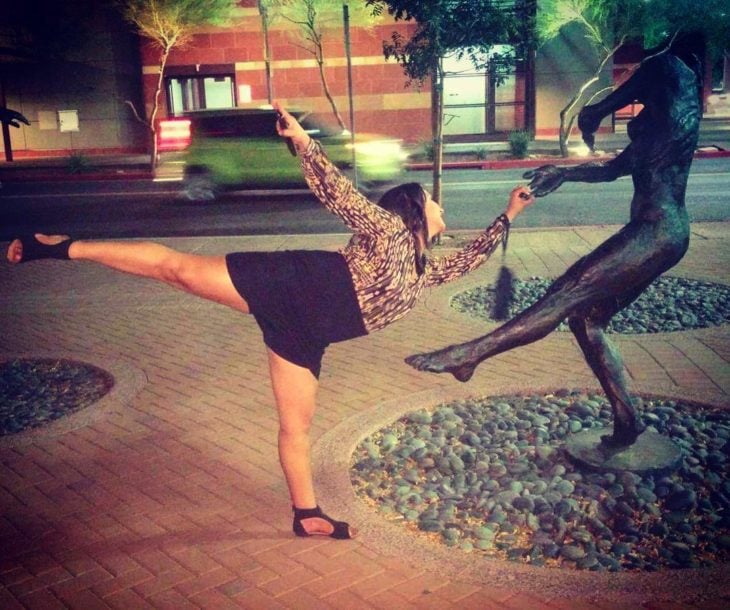 mujer posa con estatua de bailarín