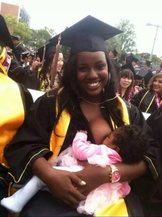 mujer amamanta a su bebé en su graduación