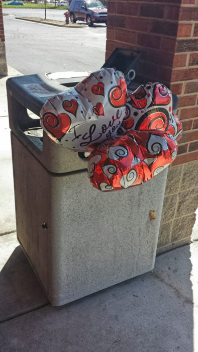 globos en forma d corazón tirados en la basura