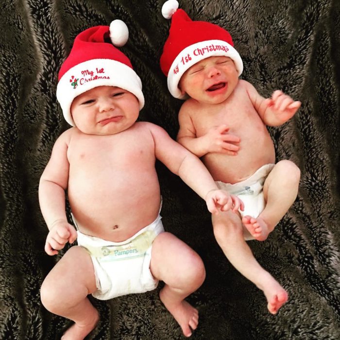 dos bebés en pañales con gorros de santa claus