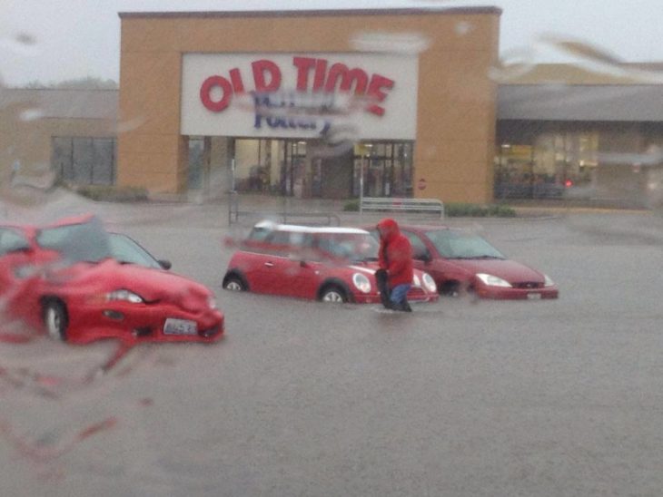 carros frente a un centro comercial inundado 