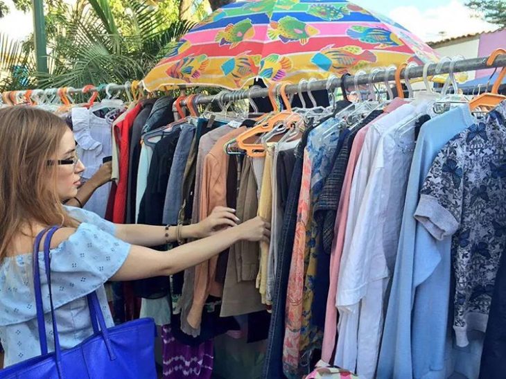 mujer hurgando ropa en un tianguis