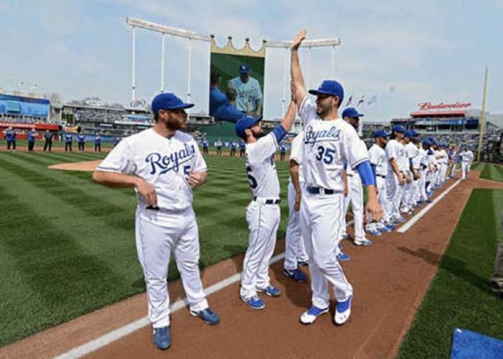 jugador de béisbol bajito trata de chocar la mano con jugador alto