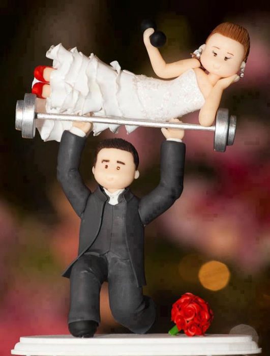 muñecos de boda, el novio levanta a la novia sobre una pesa
