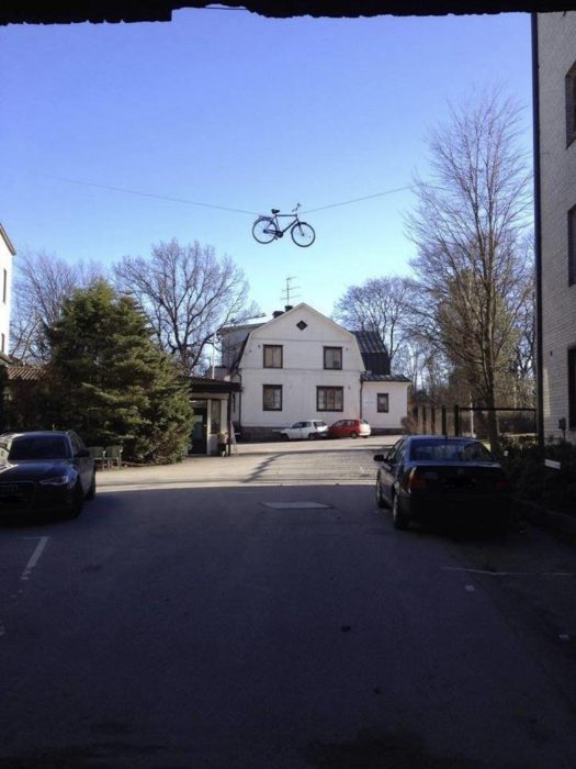 casa, a unos metros una bicicleta está colgada en un lazo