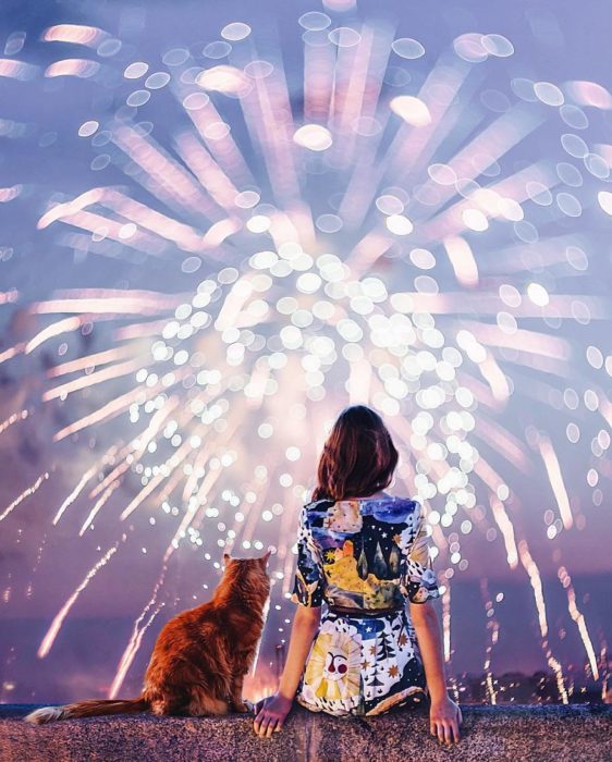 mujer con su gato viendo fuegos artiiciales