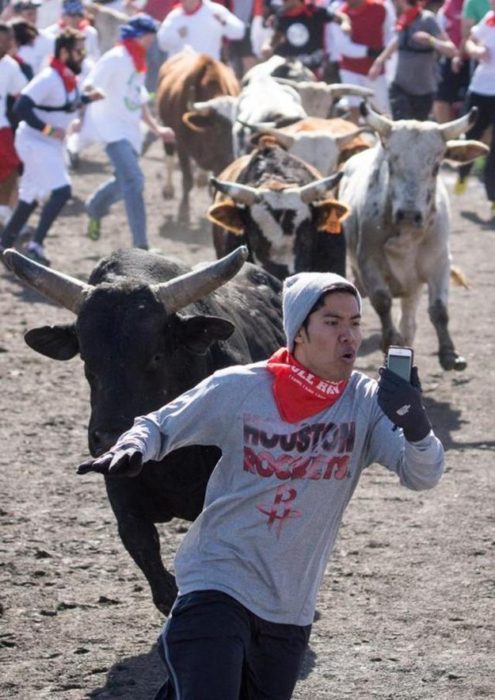 hombre se toma foto corriendo delante de un toro