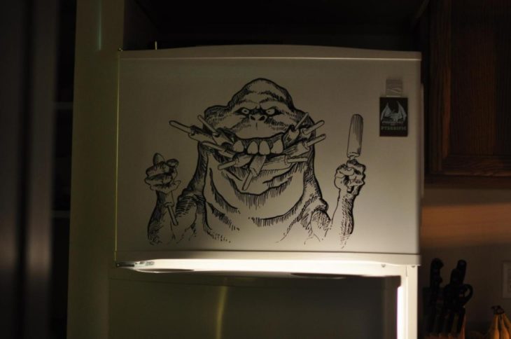 Dibujo de alguien comiendo hecho con plumón en un refrigerador 