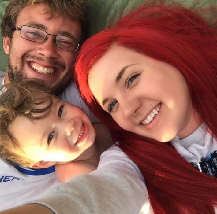 Mujer con cabello rojo junto con su esposo y su hijo