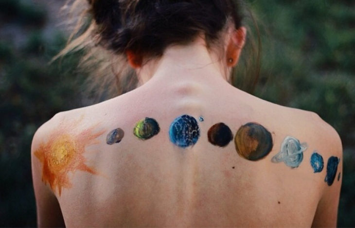 tatuaje de planetas en espalda de mujer