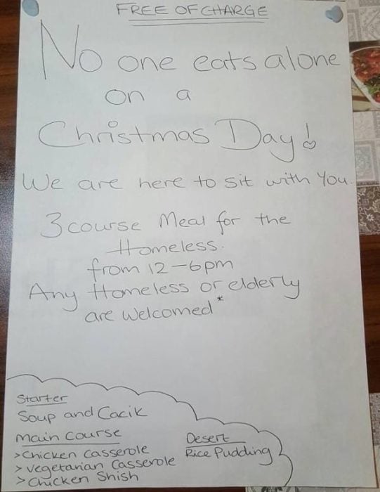 Hoja escrita a mano donde invitan a vagabundos a comer gratis y acompañados en navidad