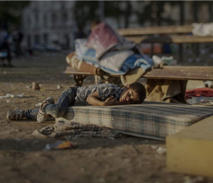 Niño sirio dormido en un colchón en la calle