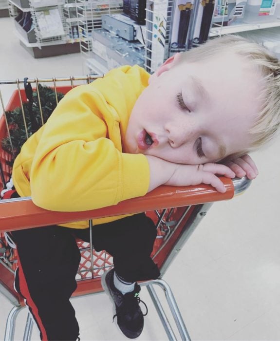 niño dormido en un carro de compras