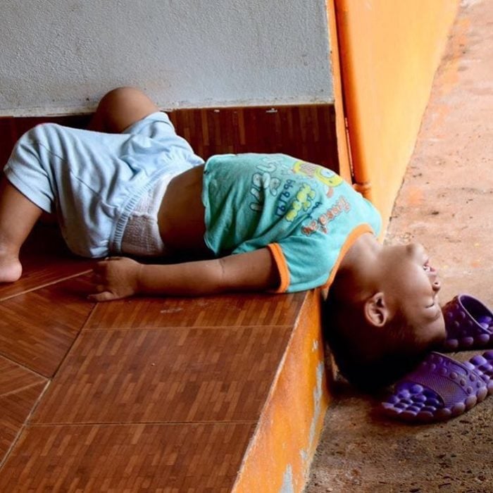 niño dormido de cabeza en las escaleras