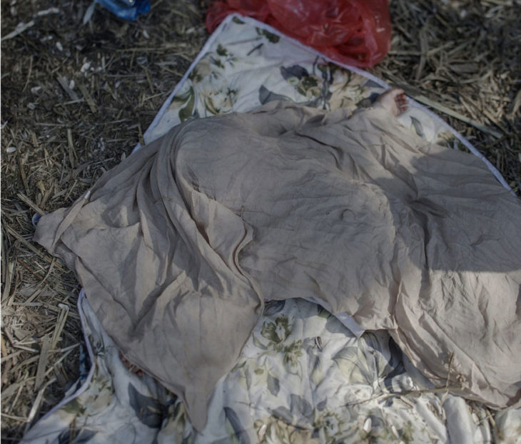 Niña cubierta por una cobija en medio del bosque