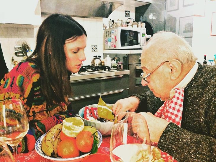 mujer dando de comer a su anciano padre