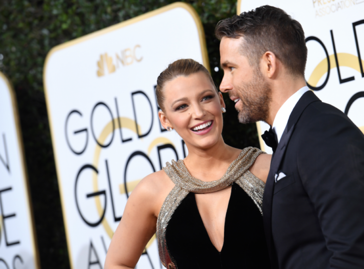 Blake Lively sonriendo mientras mira a su esposo Ryan Reynolds