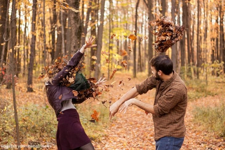 pareja aventándose hojas de arbol