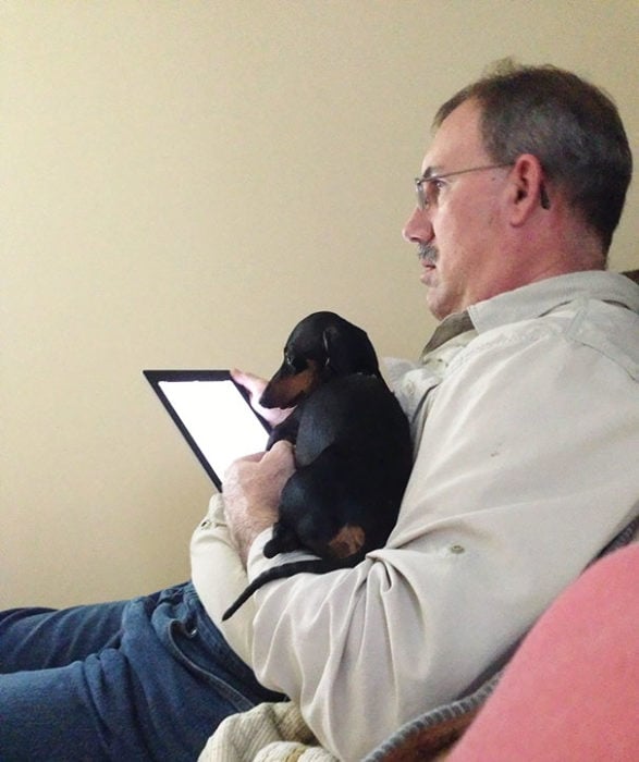 papa con ipad en mano y perro en el otro