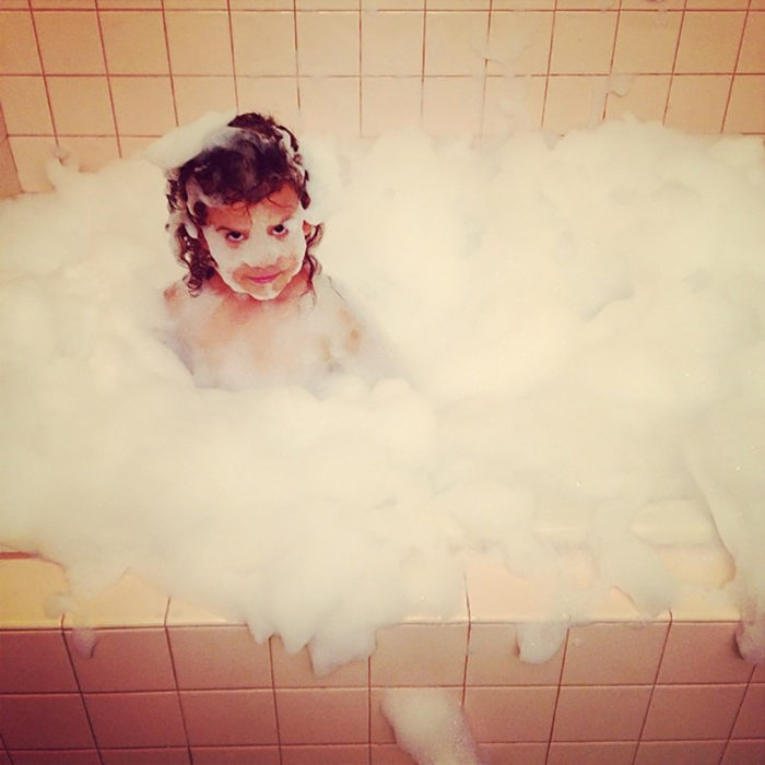 niña llena de espuma en un baño