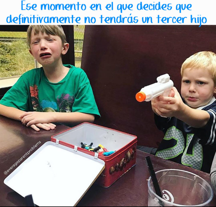 un niño juega con una pistola de agua mientras otro niño hace berrinche