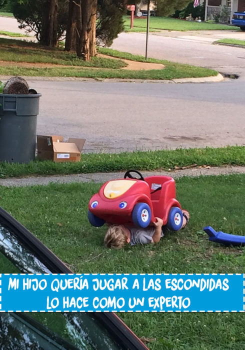 niño debajo de un carrito de juguete