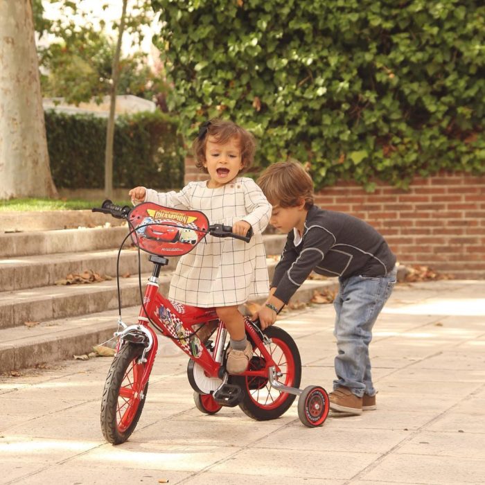 niño enseña a andar en bici a su hermanita 