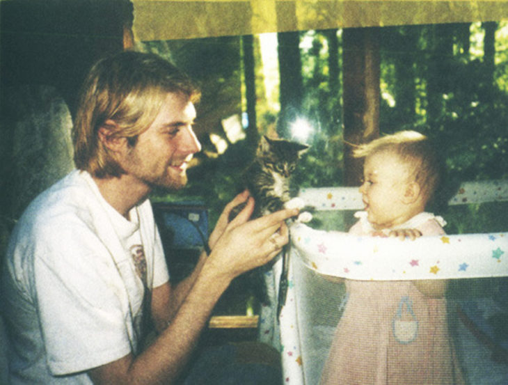 kurt cobain a los 26 años enseñándole un gato francés a su pequeña hija