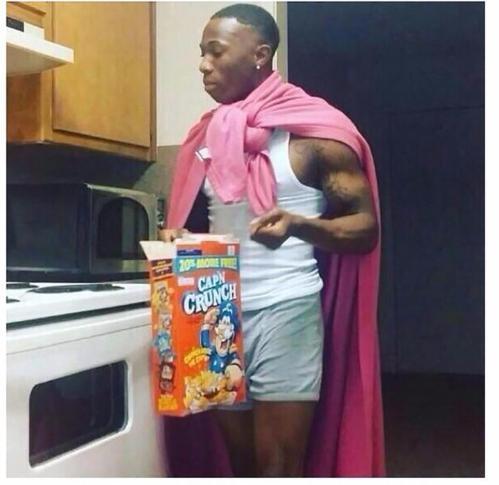 hombre negro con capa rosa que come cereal