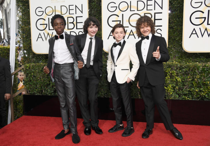 chicos de stranger things en alfombra roja y la niña editada escondida