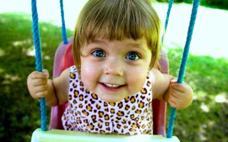 niña en un columpio sonriendo