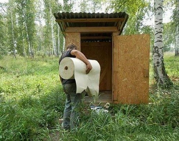 hombre cargando un enorme rollo de papel a un baño público