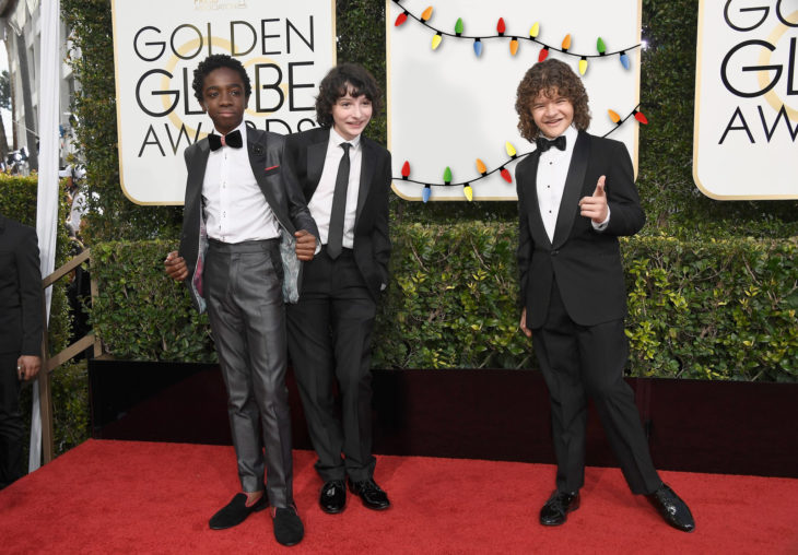 niños de stranger things en la alfombra roja con el pizarrón